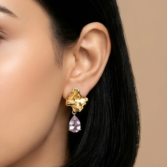 Woman wearing anti tarnish gold toned floral drop earrings with teardrop stone pendant by MahanandaFJ Atelier.
