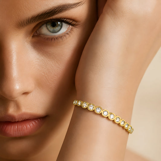 Elegant gold crystal bangle bracelet for women featuring bezel-set round crystals and a polished gold-tone finish.