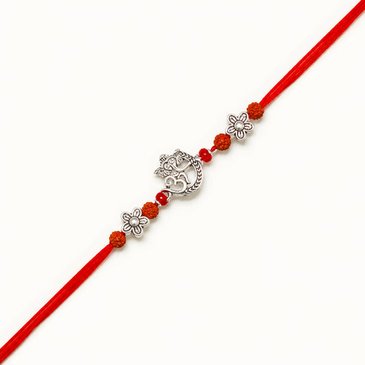 Handcrafted 925 silver Ganesh rakhi with crescent moon design, rudraksha beads, floral silver spacers and red thread for Raksha Bandhan