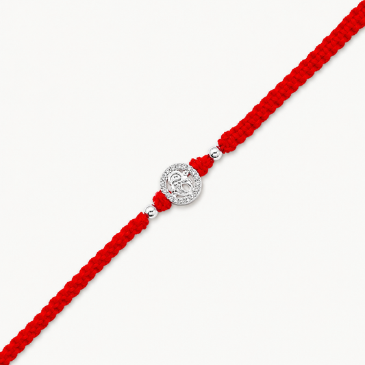 Silver Ganesh Stone Rakhi with sparkling circular design and red braided thread for Raksha Bandhan