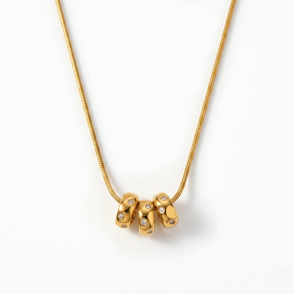 Modern gold-tone abstract pendant necklace for women featuring a polished minimalist designer pendant on a delicate chain.