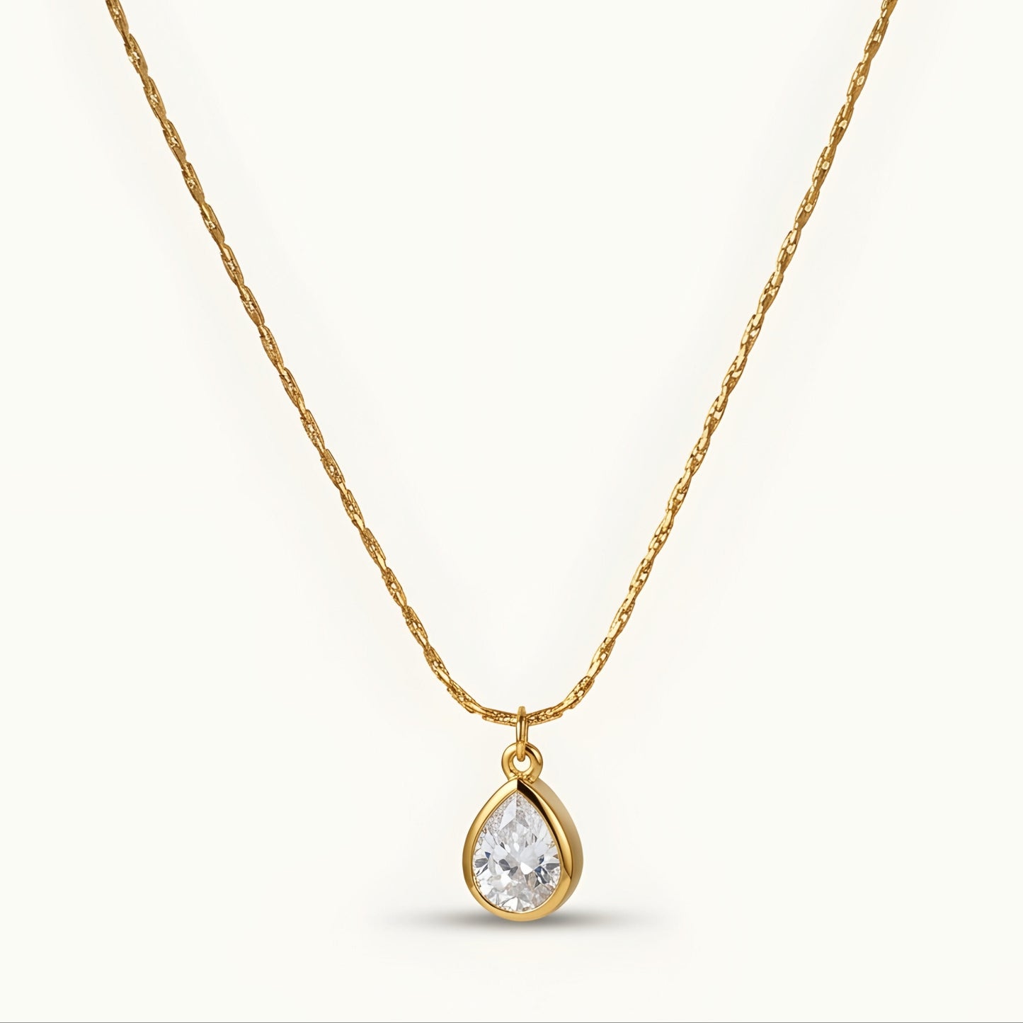 Elegant gold-tone teardrop pendant necklace with a sparkling stone, perfect for everyday wear and special occasions.