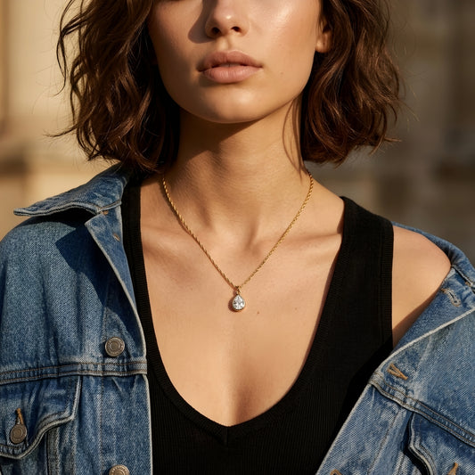 Elegant gold-tone teardrop pendant necklace with a sparkling stone, perfect for everyday wear and special occasions.