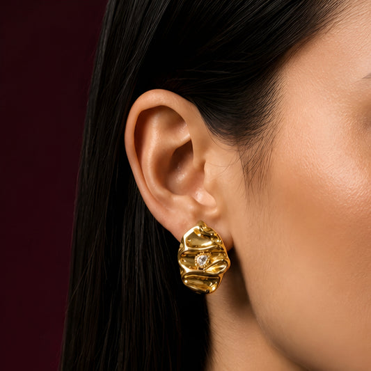 Woman wearing anti tarnish gold toned textured stud earrings with a modern crinkle design by MahanandaFJ Atelier.