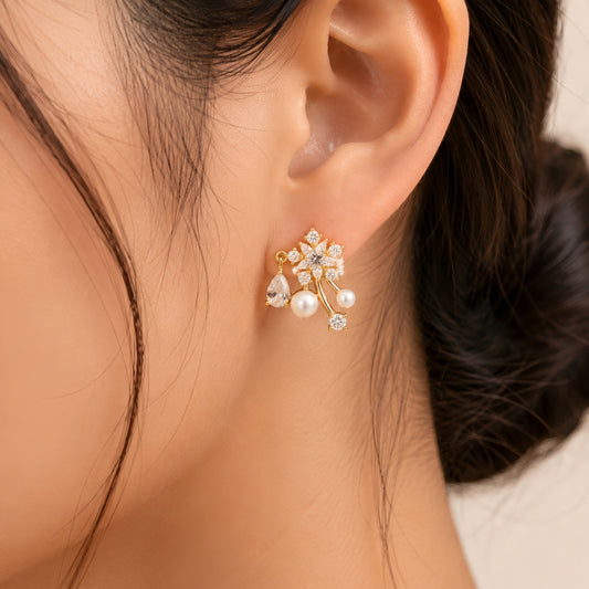 Woman wearing anti tarnish gold toned floral pearl push back earrings with sparkling stone detailing by MahanandaFJ Atelier.