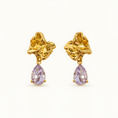 Woman wearing anti tarnish gold toned floral drop earrings with teardrop stone pendant by MahanandaFJ Atelier.