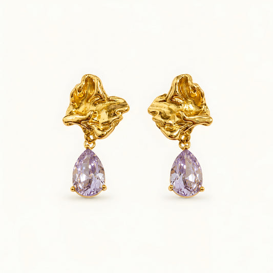 Woman wearing anti tarnish gold toned floral drop earrings with teardrop stone pendant by MahanandaFJ Atelier.