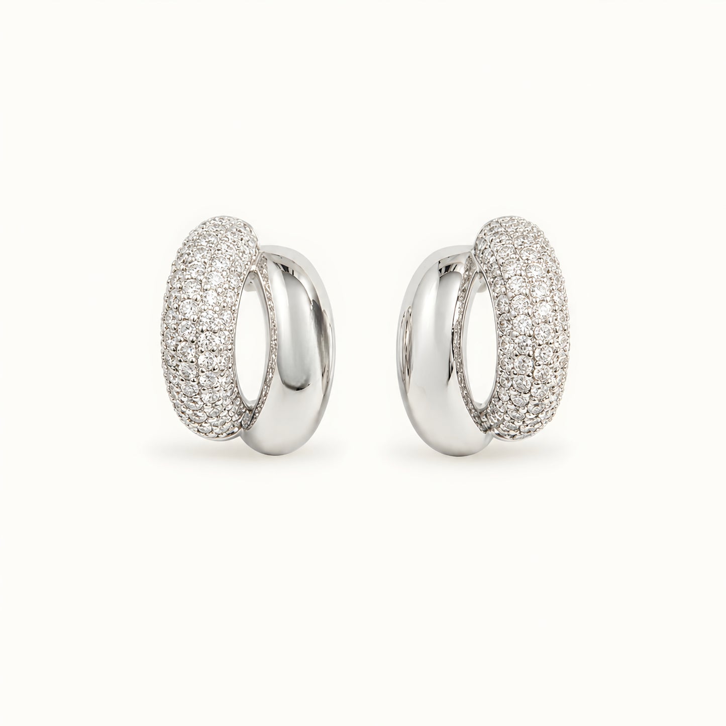 Silver toned anti tarnish pave stud earrings with dual finish and sparkling stone detailing worn on ear.