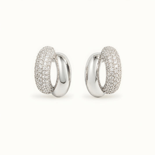 Silver toned anti tarnish pave stud earrings with dual finish and sparkling stone detailing worn on ear.
