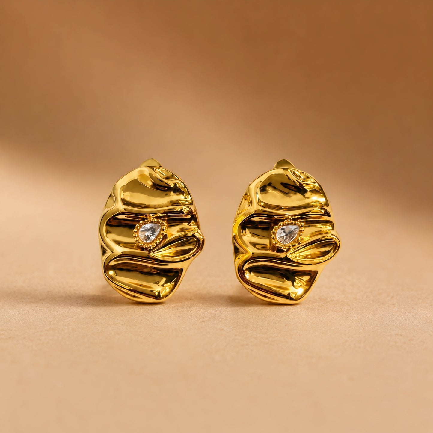 Woman wearing anti tarnish gold toned textured stud earrings with a modern crinkle design by MahanandaFJ Atelier.