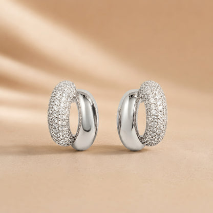 Silver toned anti tarnish pave stud earrings with dual finish and sparkling stone detailing worn on ear.