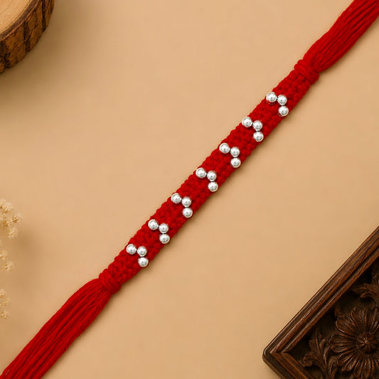 Silver handcrafted bead rakhi with polished silver beads on a braided red thread for Raksha Bandhan