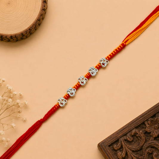 Silver Panch Om Rakhi featuring five sacred Om silver charms on a handcrafted red and yellow braided thread for Raksha Bandhan