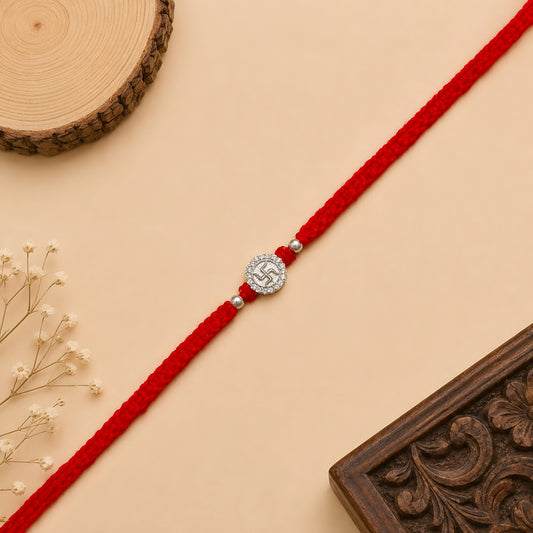 Silver Swastik stone rakhi with sacred Swastik symbol on a handcrafted red braided thread for Raksha Bandhan