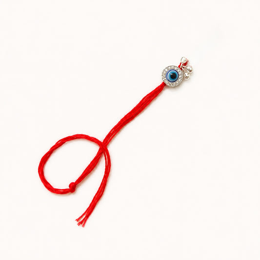 Handcrafted sterling silver evil eye Bhabhi Rakhi with sparkling stone detailing, silver ghungroo charms and premium red thread