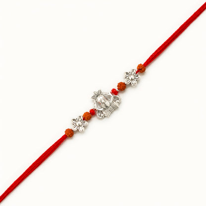 Handcrafted sterling silver Shiva rakhi with Mahadev-inspired centerpiece, rudraksha beads, floral silver accents and premium red thread