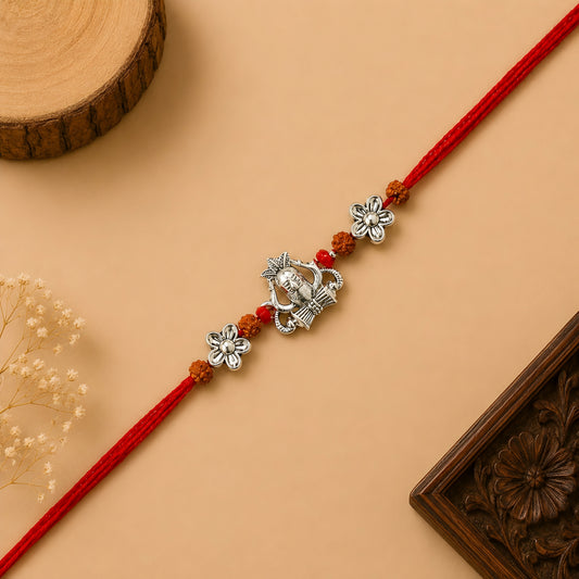 Handcrafted sterling silver Shiva rakhi with Mahadev-inspired centerpiece, rudraksha beads, floral silver accents and premium red thread