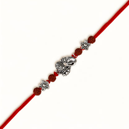 Silver Ganesh Shivling Rakhi with original Rudraksha beads, floral accents and red thread for Raksha Bandhan