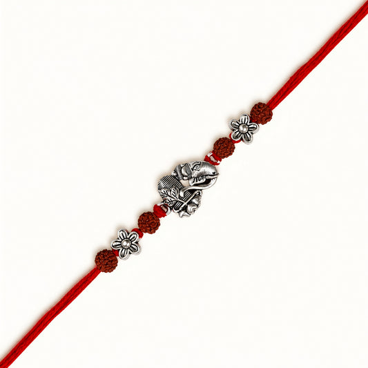 Silver Ganesh Shivling Rakhi with original Rudraksha beads, floral accents and red thread for Raksha Bandhan