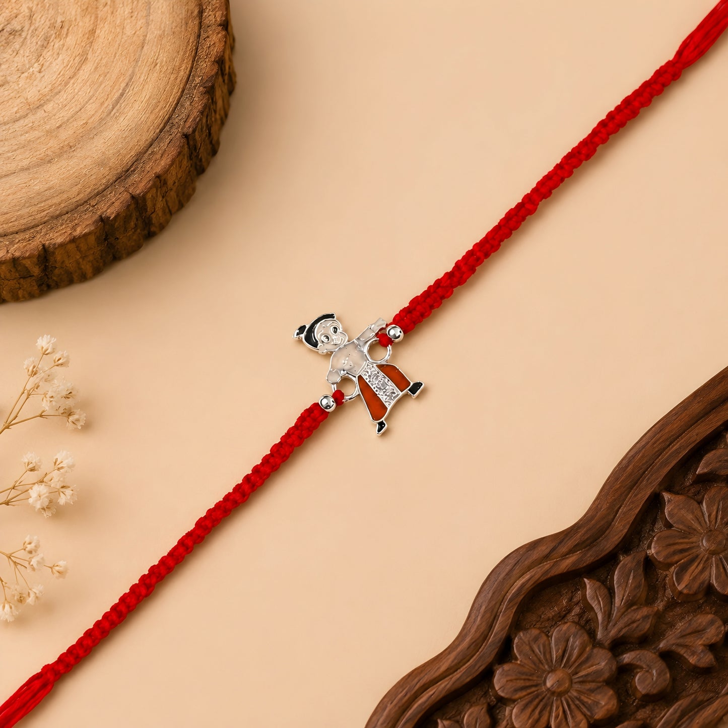 Sterling Silver Little Warrior Kids Rakhi with orange enamel cartoon centrepiece, silver beads and red woven thread