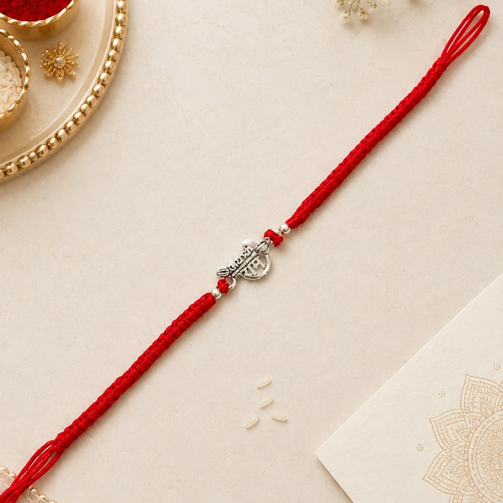 Shree Ram silver Rakhi with red braided thread and silver centerpiece