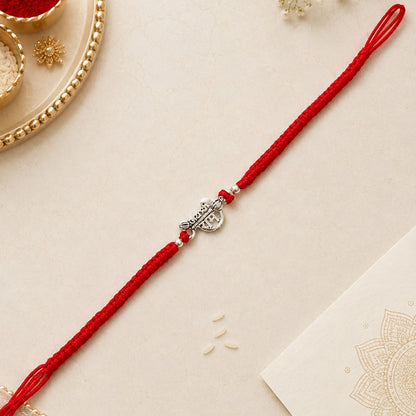 Shree Ram silver Rakhi with red braided thread and silver centerpiece