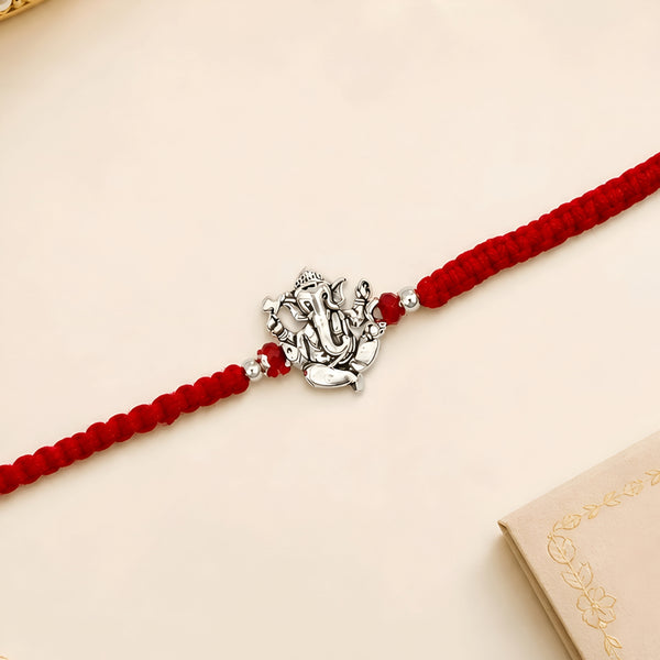 Ganesha silver Rakhi with red braided thread for brother