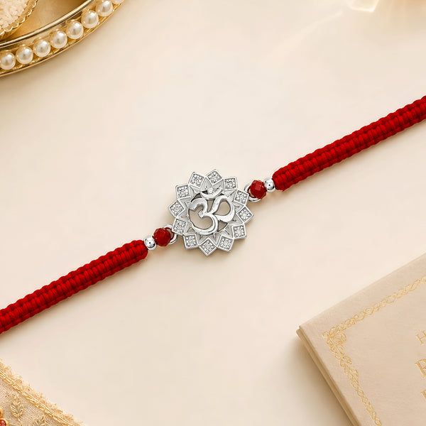 Om silver Rakhi with lotus design and red braided thread for brother