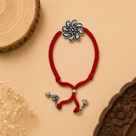 Sterling Silver Floral Lumba Rakhi for Bhabhi with oxidised flower centrepiece, red woven thread and hanging silver charms