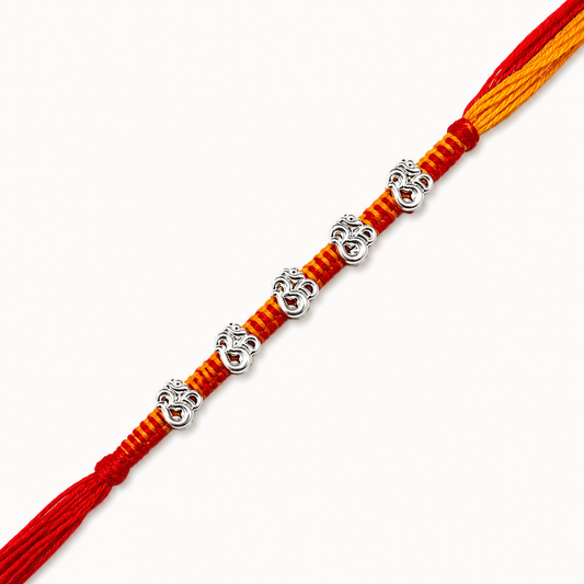 Silver Panch Om Rakhi featuring five sacred Om silver charms on a handcrafted red and yellow braided thread for Raksha Bandhan