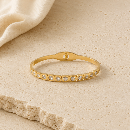 Elegant gold crystal bangle bracelet for women featuring bezel-set round crystals and a polished gold-tone finish.