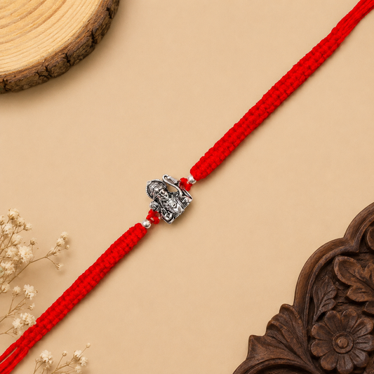 Silver Shri Ram Dhanush Rakhi with Lord Ram bow design and red braided thread for brother on Raksha Bandhan