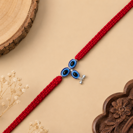 Sterling Silver Triple Nazar Bhabhi Rakhi with three blue evil eye motifs, silver charm and red woven thread