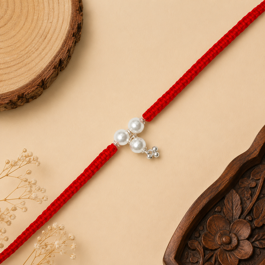 Sterling Silver Triple Pearl Bhabhi Rakhi with three white pearl beads, silver charm and broad red woven thread